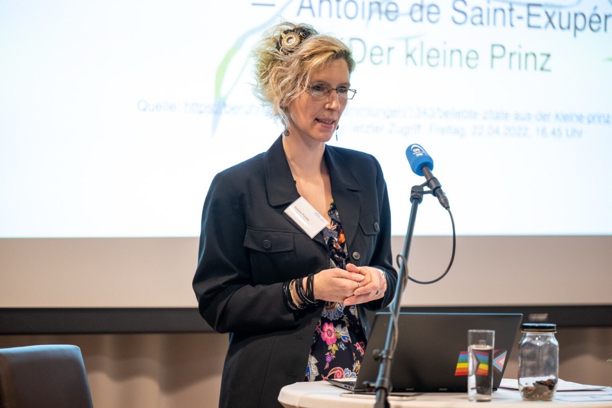 Sabine Finster, approbierte Kinder- und Jugendlichenpsychotherapeutin aus Dachau, spricht bei einer Fachveranstaltung des Bayerischen Jugendrings vor einer Leinwand mit einem Zitat aus „Der kleine Prinz“